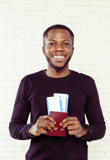 Image of a man holding a passport with two hands and smiling